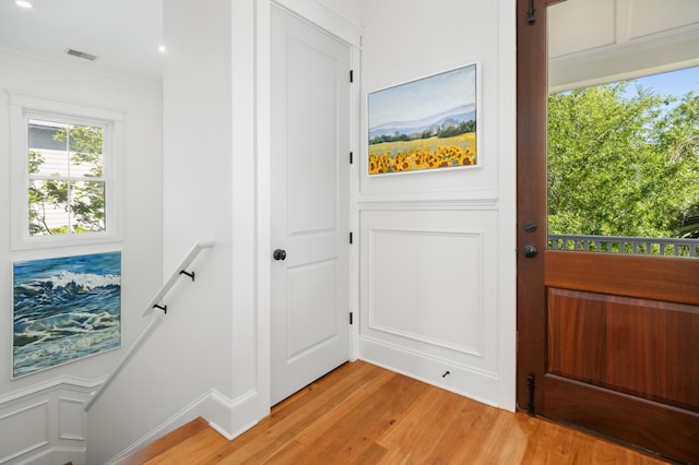 1543 Wando Landing St, Charleston, SC 29492 - doorway to outside with light wood finished floors, crown molding, and a decorative wall
