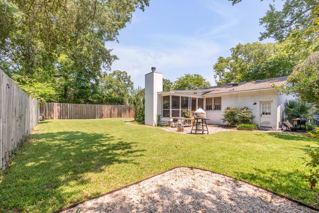 view of yard with a sunroom and a patio