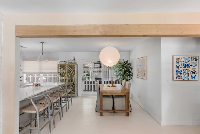 dining space featuring beamed ceiling and sink