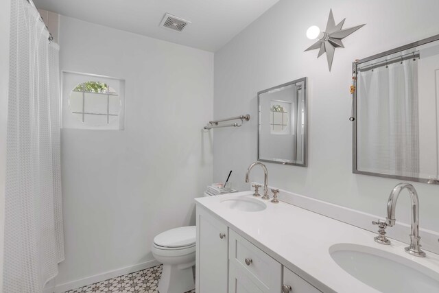 bathroom with vanity, curtained shower, and toilet