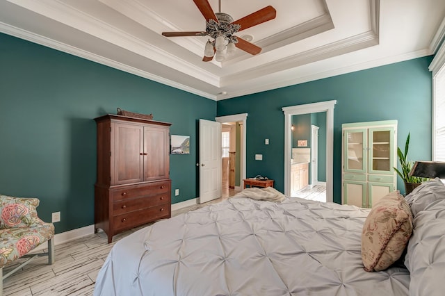 bedroom featuring baseboards, multiple windows, a raised ceiling, and crown molding