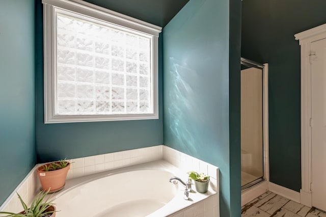 bathroom with a stall shower and a garden tub