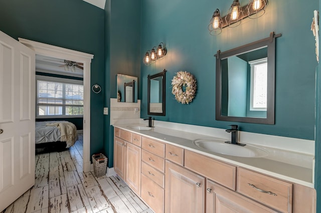 ensuite bathroom with connected bathroom, a sink, ceiling fan, and double vanity