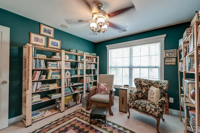 living area with a ceiling fan, carpet flooring, visible vents, and baseboards