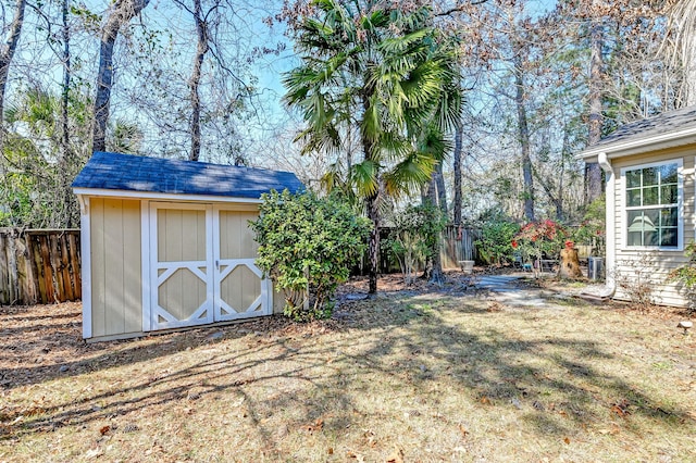 view of yard with an outdoor structure, fence, and a storage unit