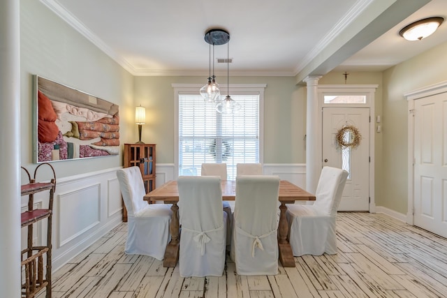 dining area with a wainscoted wall, ornate columns, light wood-type flooring, and crown molding