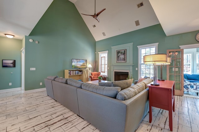 living room featuring light wood-type flooring, a healthy amount of sunlight, visible vents, and a fireplace