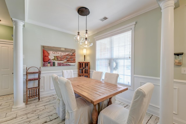 dining space with a wainscoted wall, ornamental molding, visible vents, and ornate columns