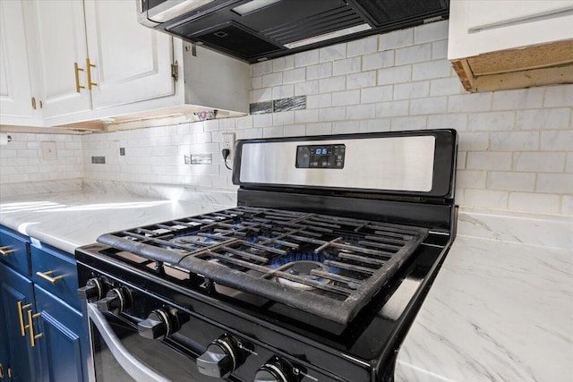 kitchen featuring ventilation hood, blue cabinetry, decorative backsplash, white cabinetry, and stainless steel gas stove