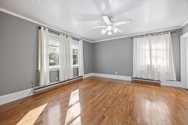 spare room with hardwood / wood-style floors, a baseboard heating unit, plenty of natural light, and ornamental molding