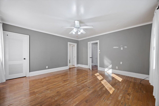 unfurnished room featuring crown molding, baseboards, and wood-type flooring