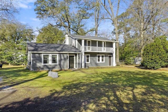 view of front of house with a balcony and a front lawn