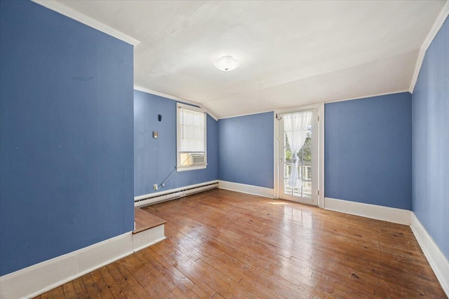 spare room featuring a baseboard heating unit, wood-type flooring, baseboards, and ornamental molding