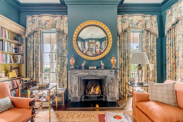 living area with a wealth of natural light, crown molding, and hardwood / wood-style flooring