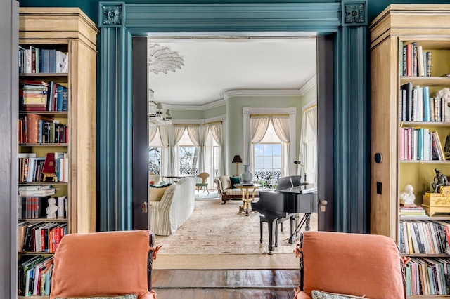 sitting room with ornamental molding and wood-type flooring