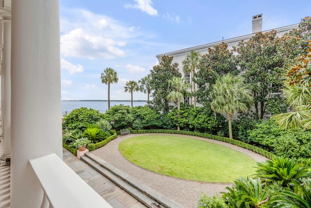 view of home's community featuring a water view and a lawn