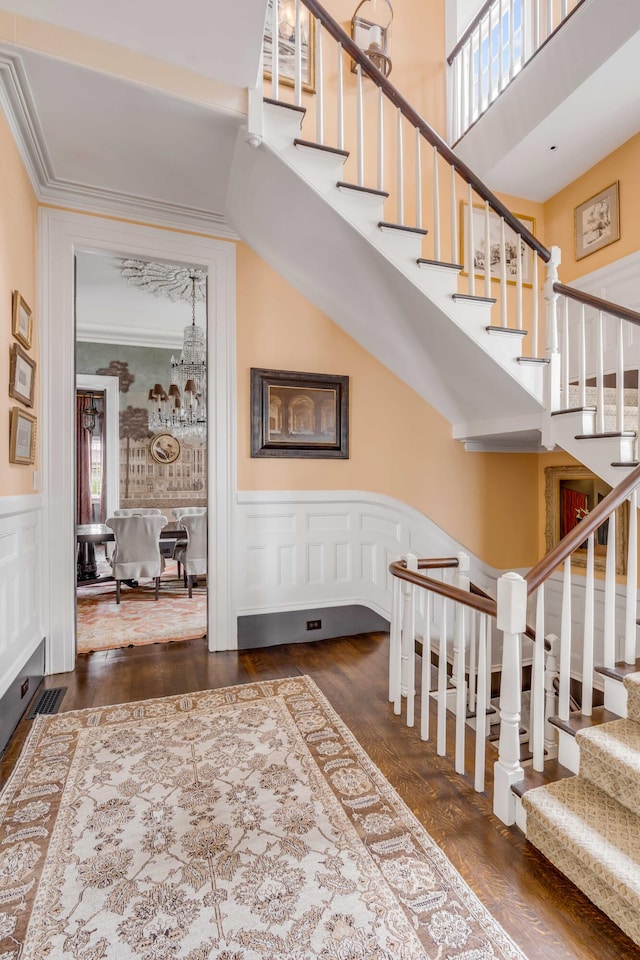 staircase with a high ceiling, hardwood / wood-style flooring, and plenty of natural light