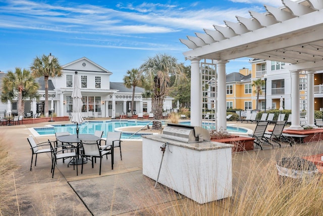 view of swimming pool with a grill, a pergola, exterior kitchen, and a patio area