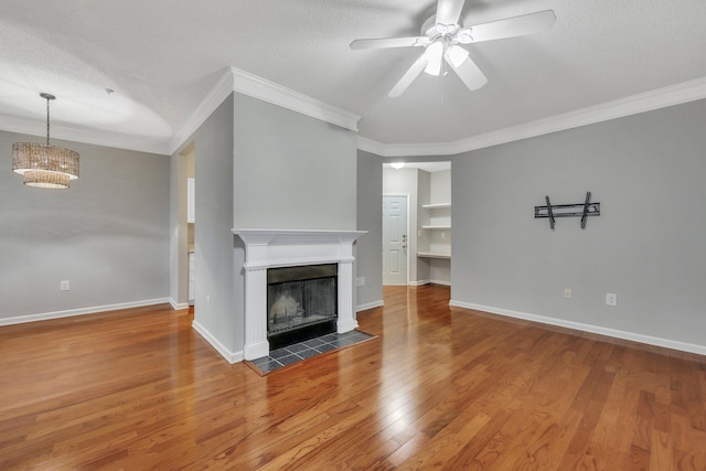 unfurnished living room with crown molding, ceiling fan, wood-type flooring, and a textured ceiling