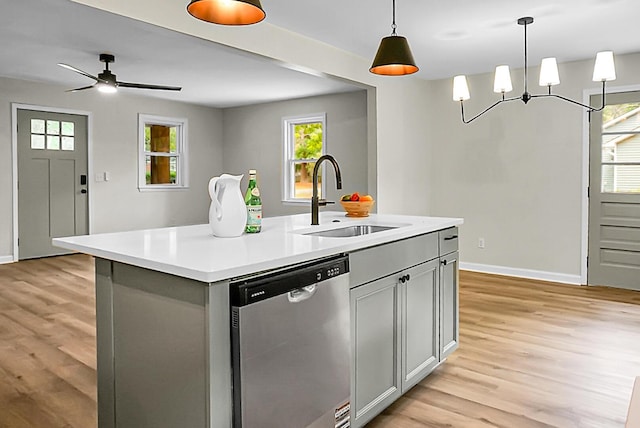 kitchen with dishwasher, a sink, light wood-style flooring, and plenty of natural light
