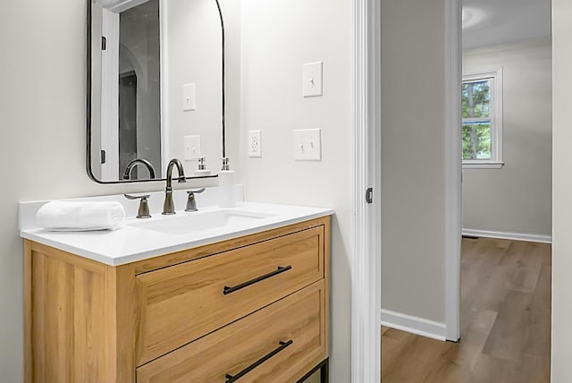 bathroom with wood finished floors, vanity, and baseboards