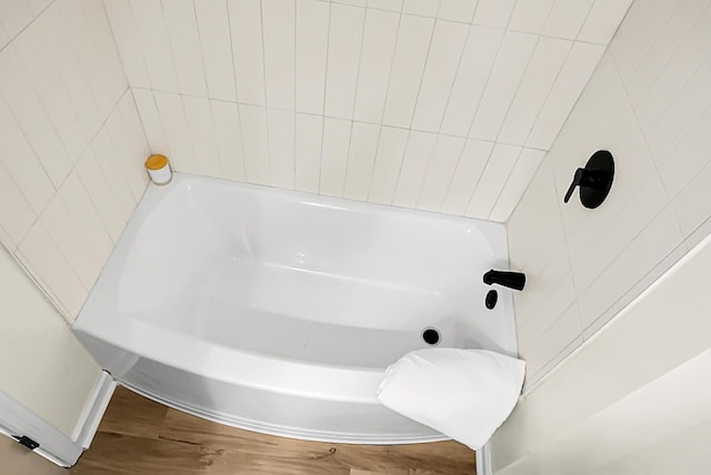 bathroom featuring wood finished floors and a bathtub