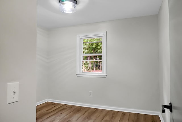empty room featuring wood finished floors and baseboards