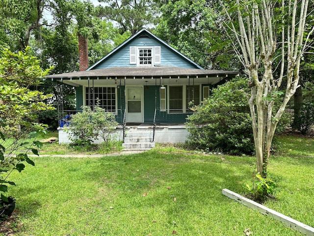 1640 Dogwood Rd, Charleston, SC 29414 - bungalow-style house featuring a chimney, a porch, roof with shingles, and a front yard