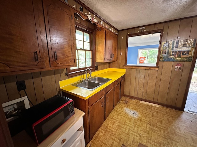 1640 Dogwood Rd, Charleston, SC 29414 - kitchen featuring a sink, healthy amount of natural light, a textured ceiling, black microwave, and wooden walls
