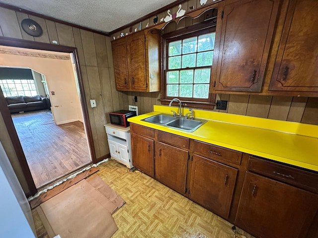 1640 Dogwood Rd, Charleston, SC 29414 - kitchen featuring a sink, a textured ceiling, wood walls, light countertops, and black microwave