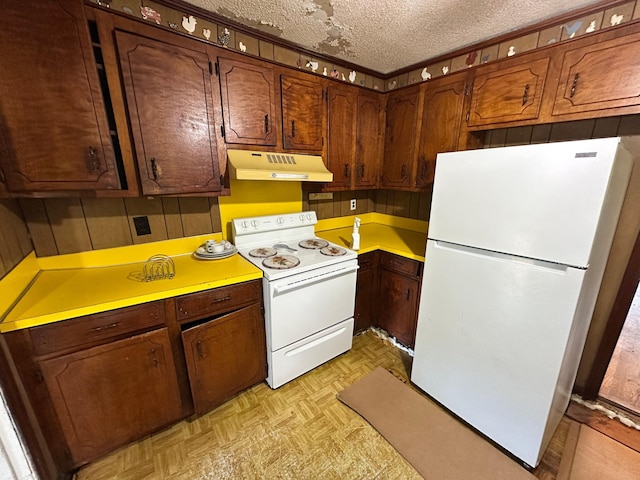 1640 Dogwood Rd, Charleston, SC 29414 - kitchen with white appliances, under cabinet range hood, light countertops, a textured ceiling, and wood walls