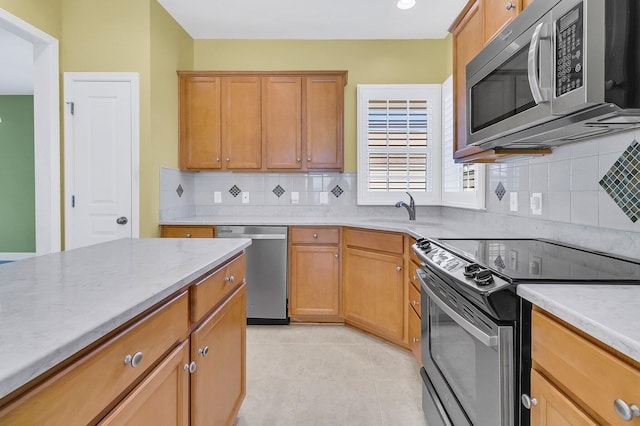 kitchen featuring light tile patterned flooring, appliances with stainless steel finishes, backsplash, and sink