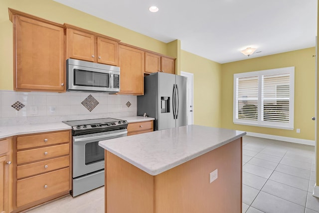 kitchen featuring backsplash, a kitchen island, stainless steel appliances, and light tile patterned floors