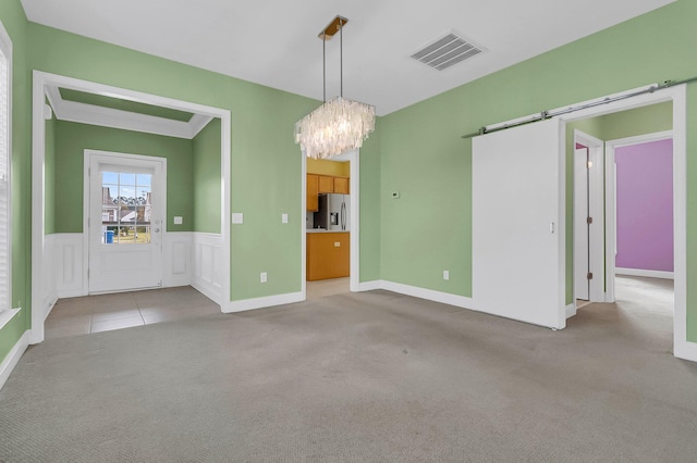 interior space featuring a barn door, light colored carpet, and an inviting chandelier