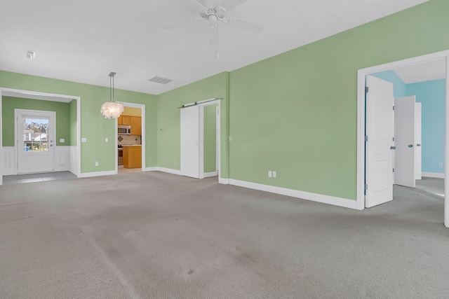 unfurnished living room with ceiling fan and light carpet