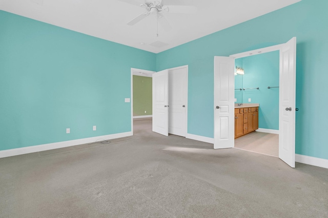 unfurnished bedroom featuring ceiling fan, ensuite bathroom, and light carpet