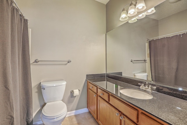 bathroom with toilet, vanity, and tile patterned floors