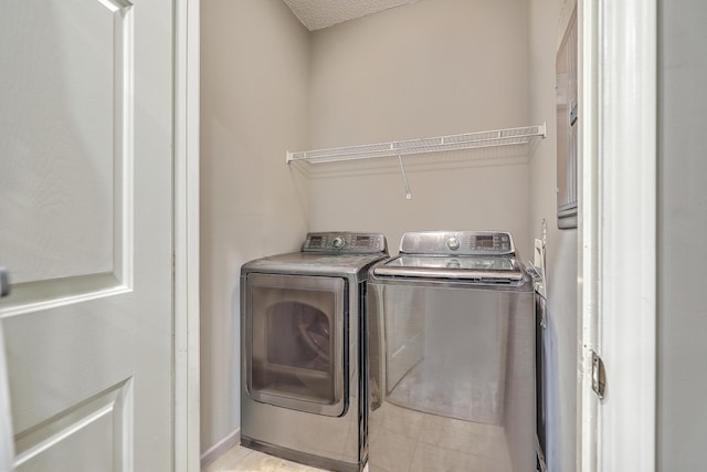 laundry area featuring separate washer and dryer and a textured ceiling