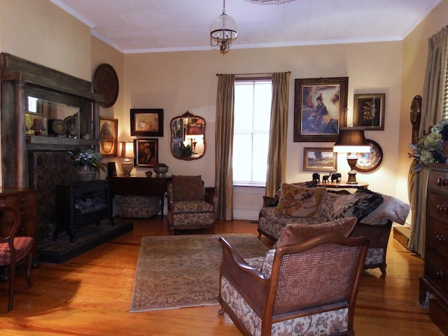 living area with an inviting chandelier, ornamental molding, and light hardwood / wood-style flooring