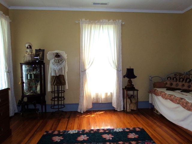 bedroom with wood-type flooring and ornamental molding