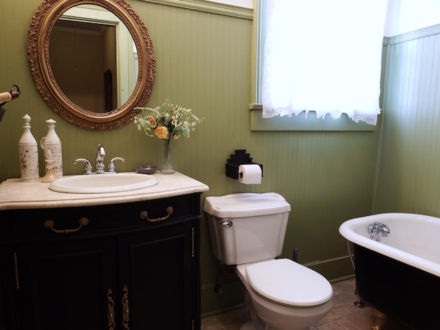 bathroom with toilet, vanity, tile patterned floors, and a tub