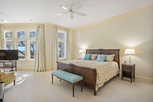 carpeted bedroom featuring ceiling fan and crown molding