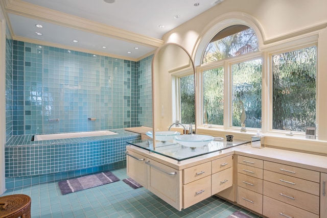 bathroom featuring vanity, a relaxing tiled tub, tile patterned floors, and crown molding