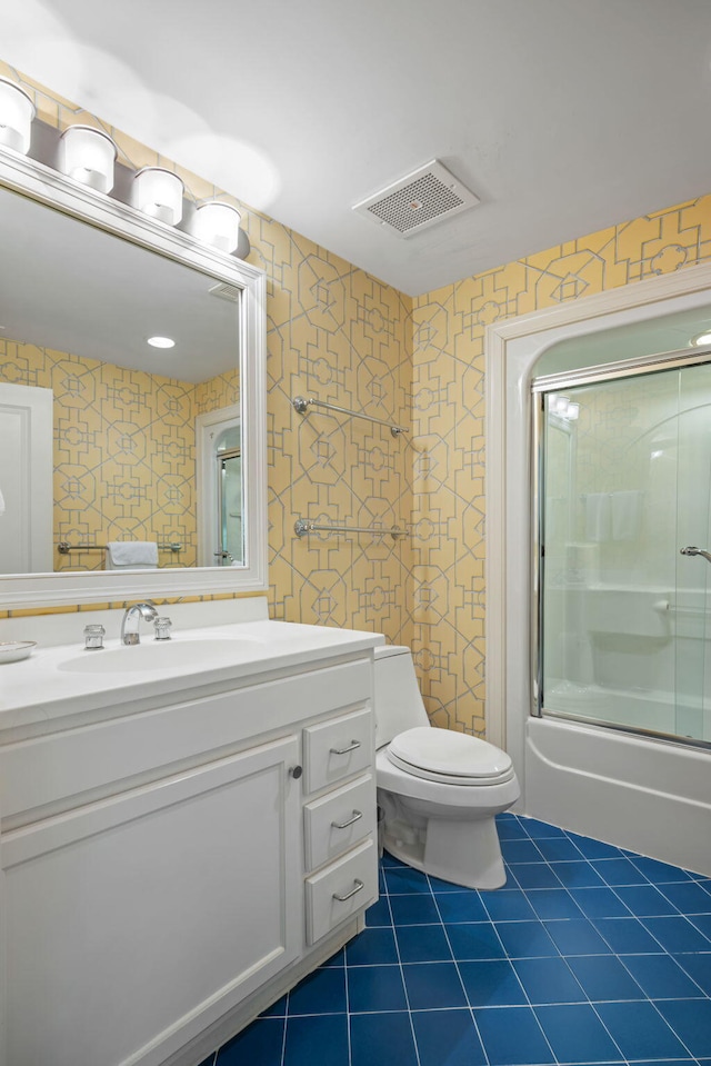 full bathroom with toilet, vanity, tile patterned floors, and bath / shower combo with glass door