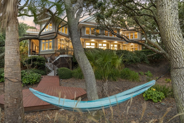 back house at dusk with a wooden deck