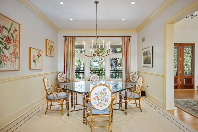 dining area with a chandelier, ornamental molding, and light hardwood / wood-style flooring