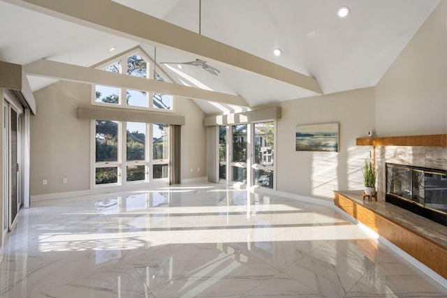 unfurnished living room featuring a high end fireplace, high vaulted ceiling, and plenty of natural light