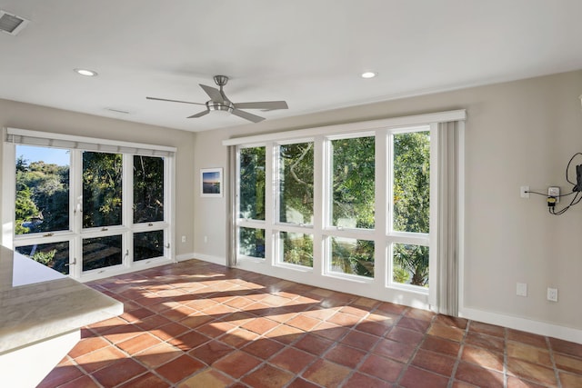 empty room with ceiling fan and plenty of natural light