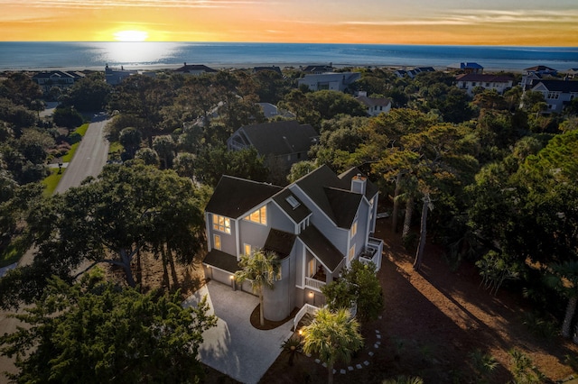 aerial view at dusk featuring a water view