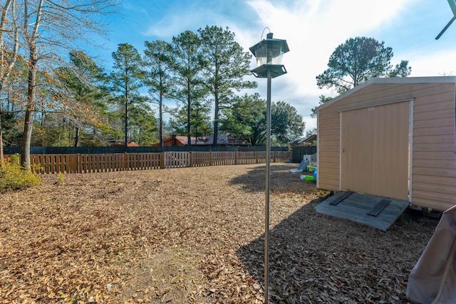 view of yard with a storage shed and a playground